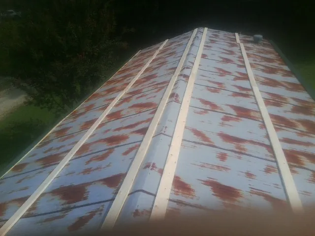 Rusted metal roof panels with new wood purlins before replacement — Storm Damage Roof Repair in Vanceboro by Roofing Brothers